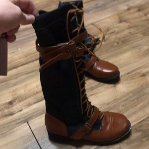 Dark blue jean and brown knee high boots .